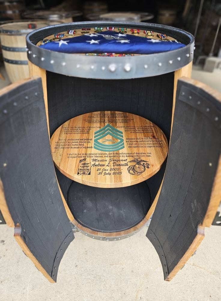Open barrel cabinet showing a round engraved interior shelf beneath its military shadow-box top.