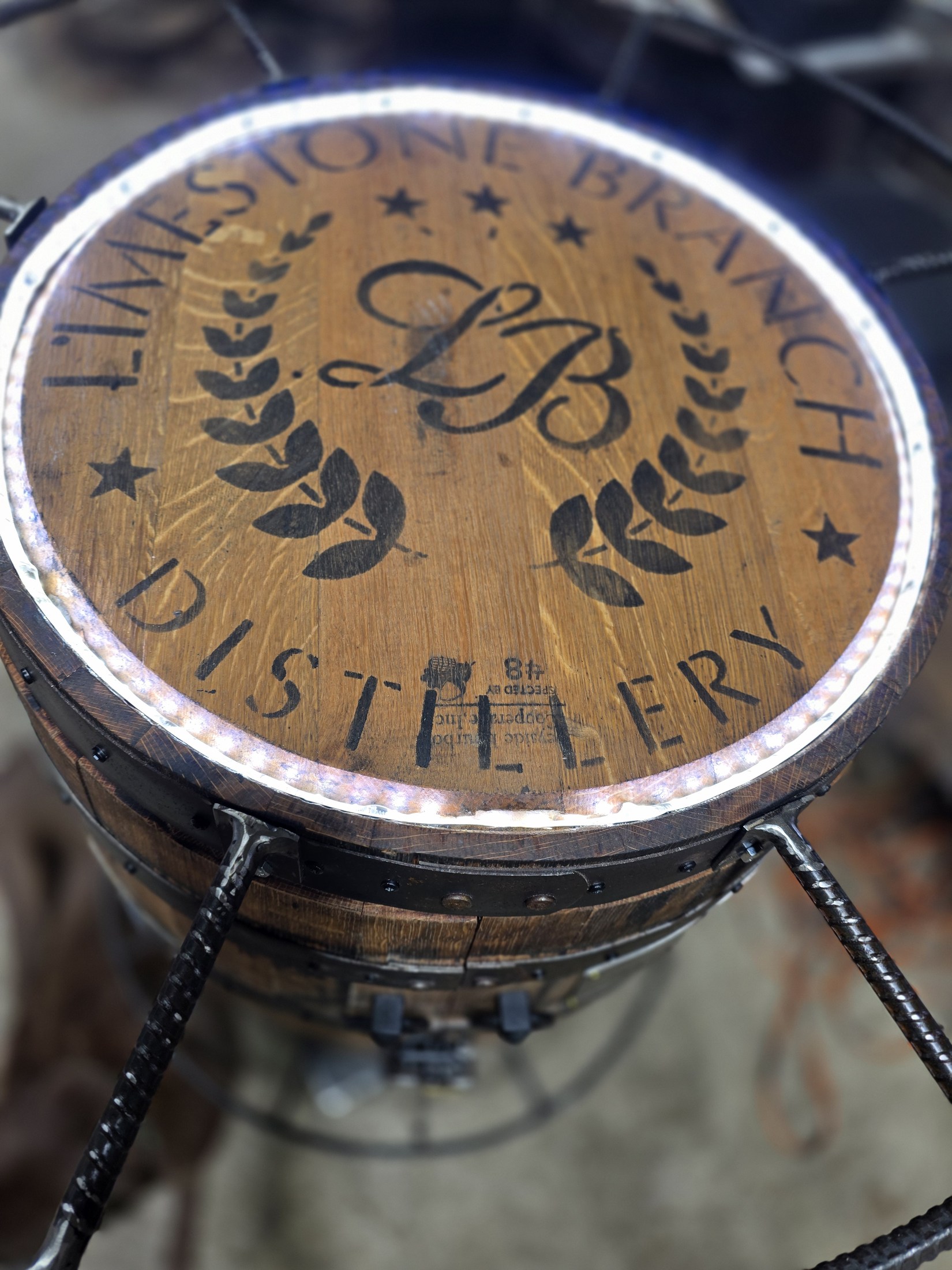 Limestone Branch Distillery engraving beneath the glass top of a barrel cabinet, surrounded by a ring of white light.