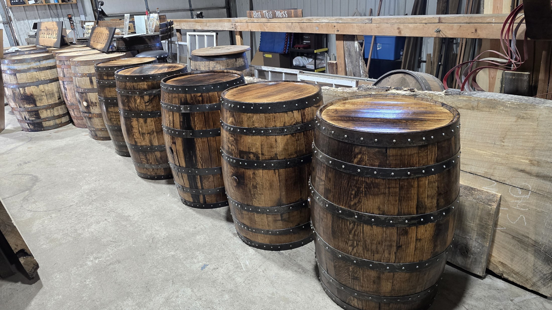 Finished barrels lined up in the SHB workshop, with The Perch and The Cellar signs behind them.