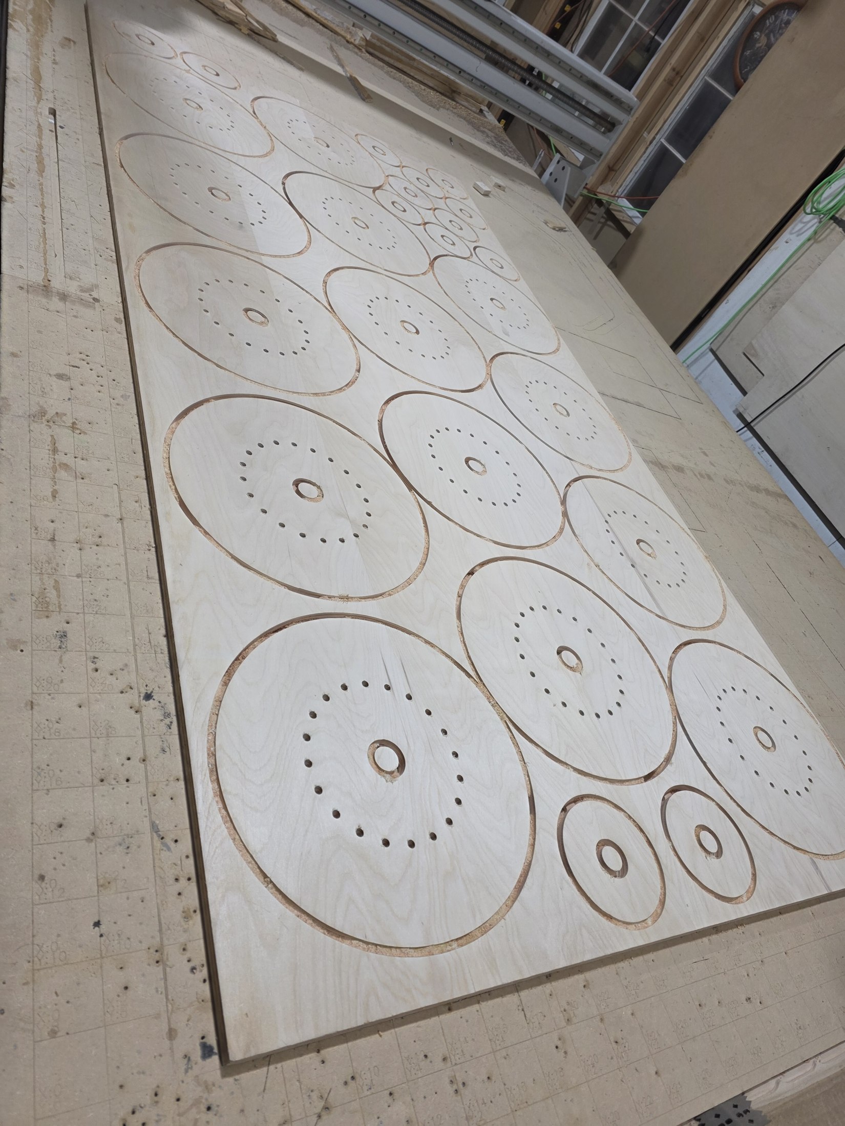 Nested circular parts cut from a sheet on the CNC table.