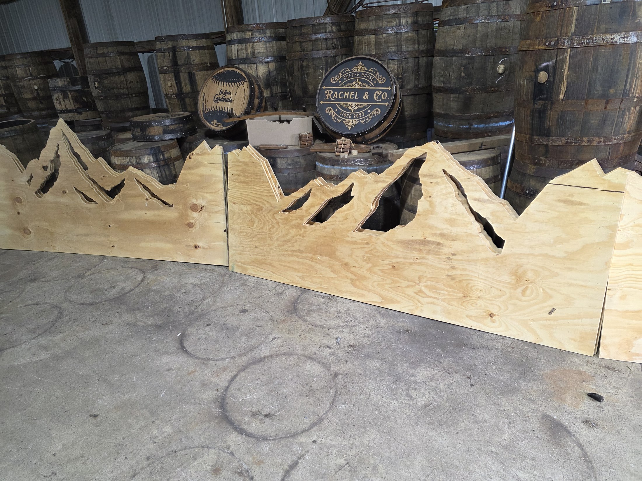 Plywood mountain silhouettes and cutout panels leaning together in the workshop.