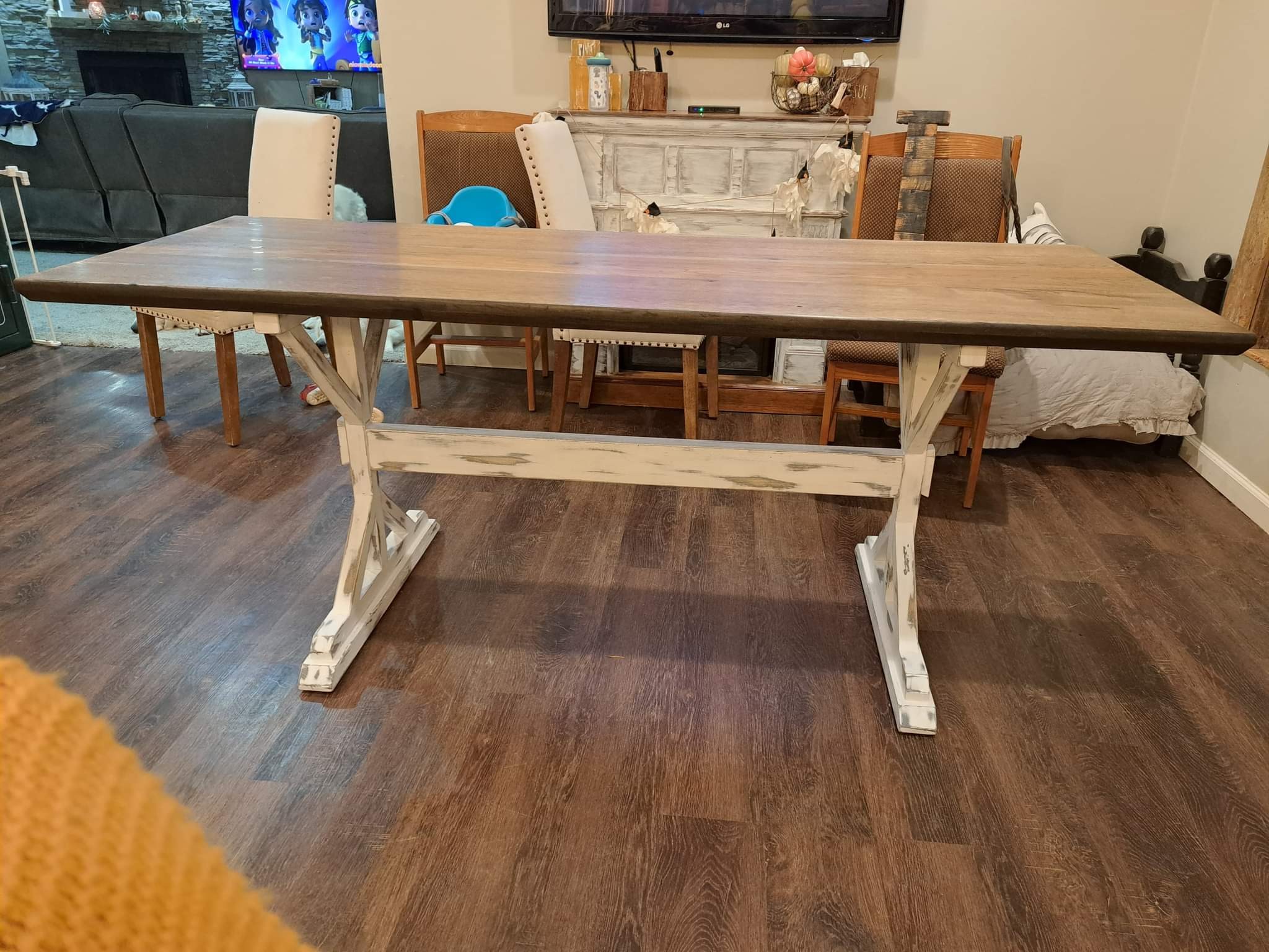 Long wooden dining table with a trestle base in its dining-room setting.