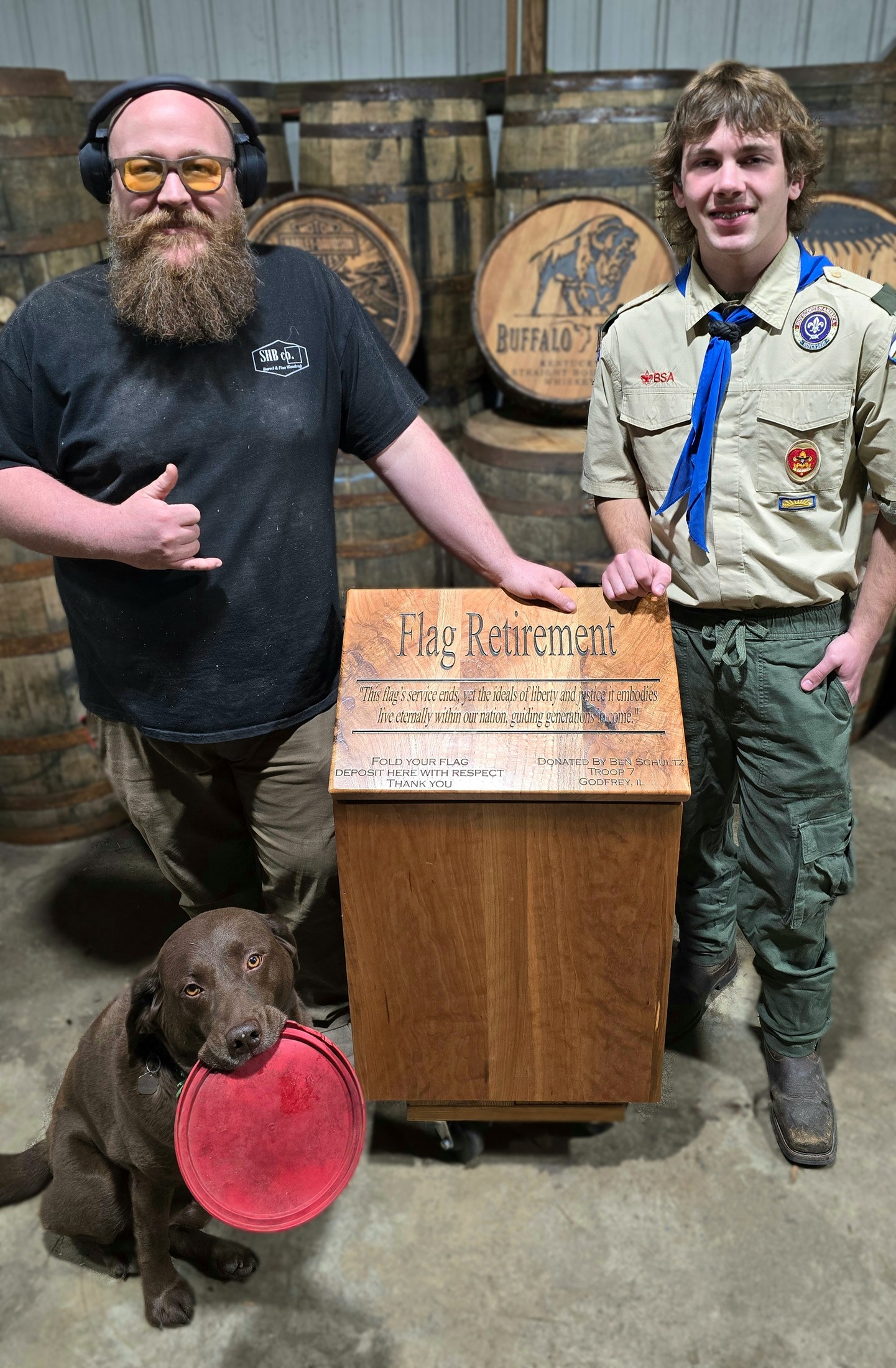 Ryan and a Scout stand beside the finished wooden flag-retirement box in the SHB workshop.