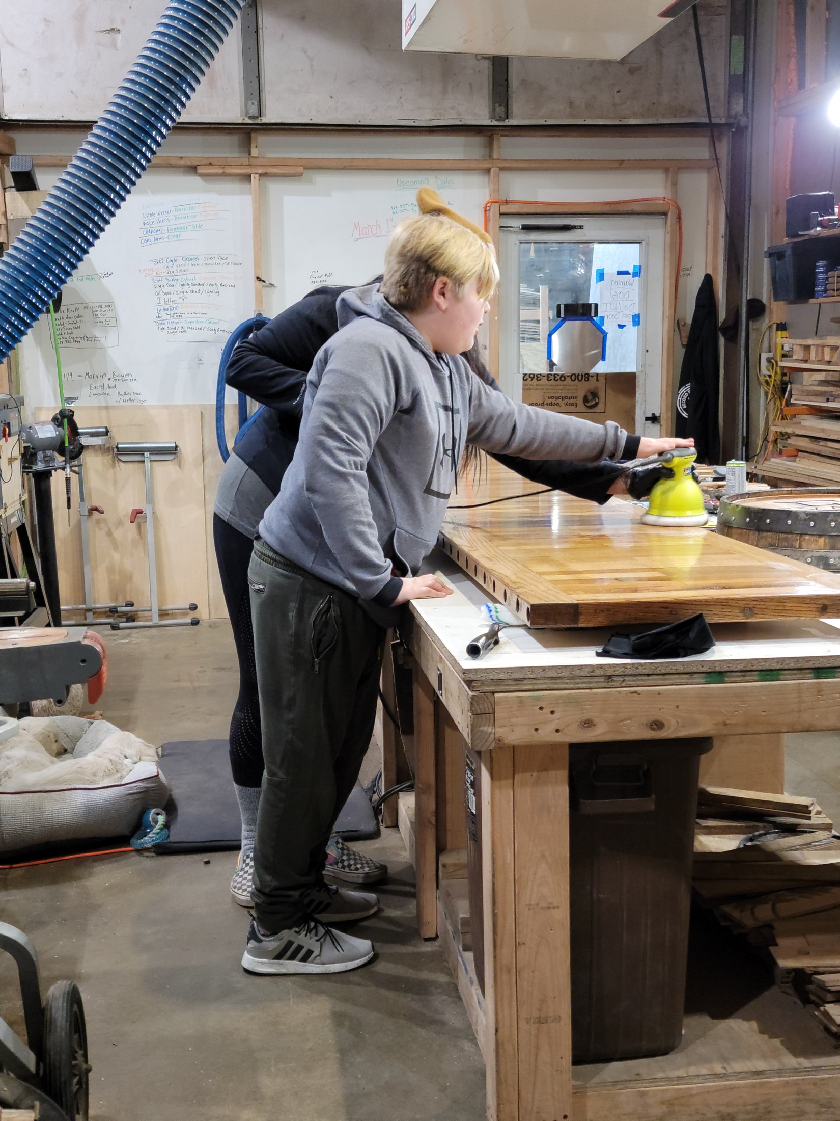Craftsperson sanding the long bar surface in the SHB workshop.