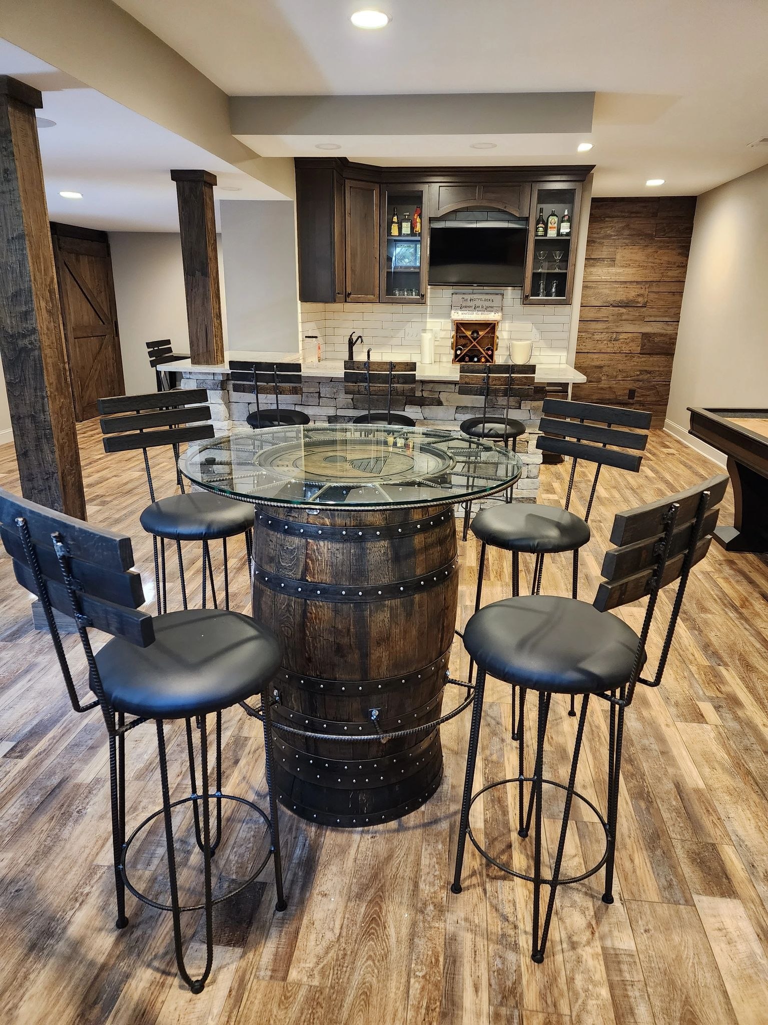 Barrel-based tables and stools arranged in a finished dining area.