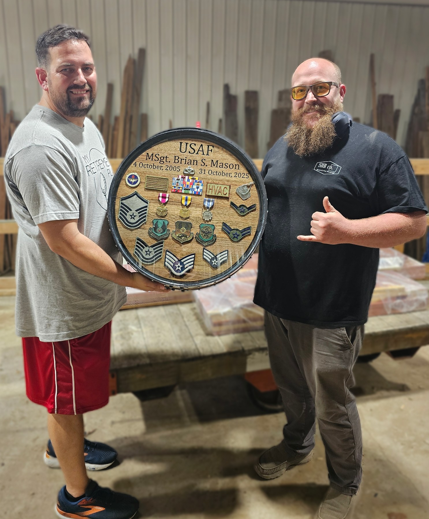Brian Mason and Ryan holding the completed circular Air Force shadow box in the SHB shop.
