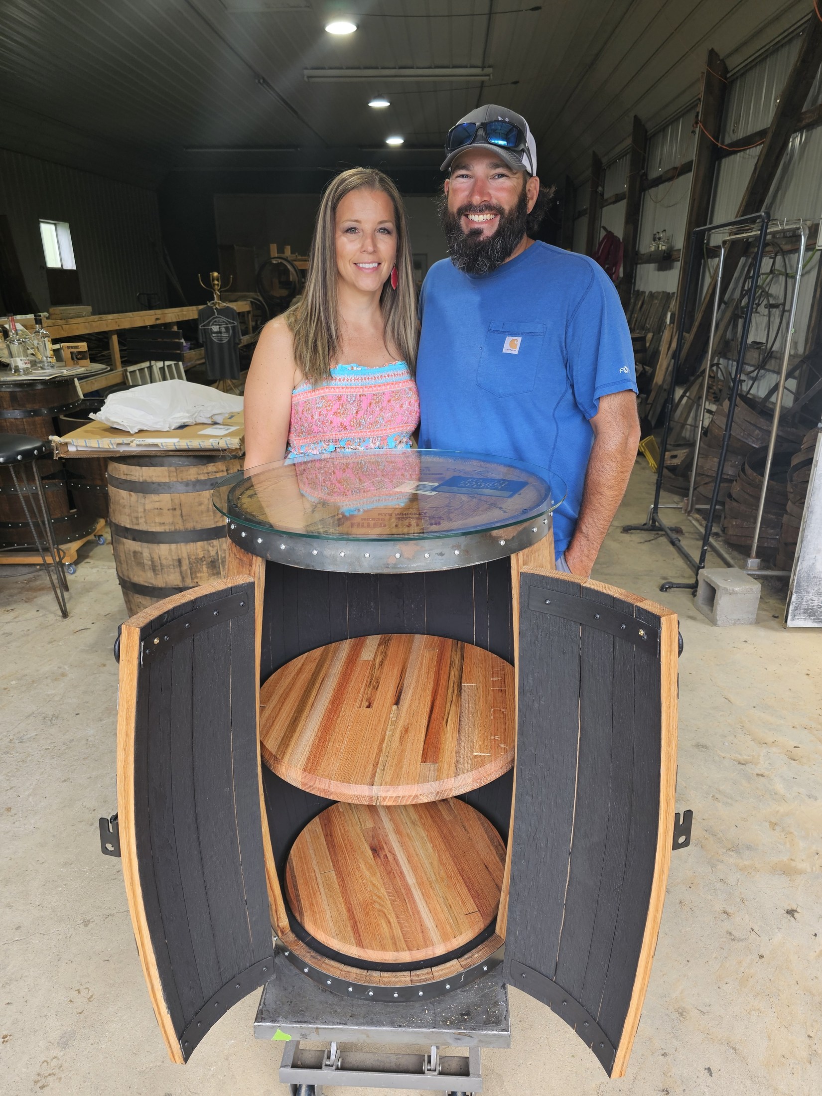 Nick and Robin behind their completed barrel cabinet in the SHB shop, with the curved doors open.