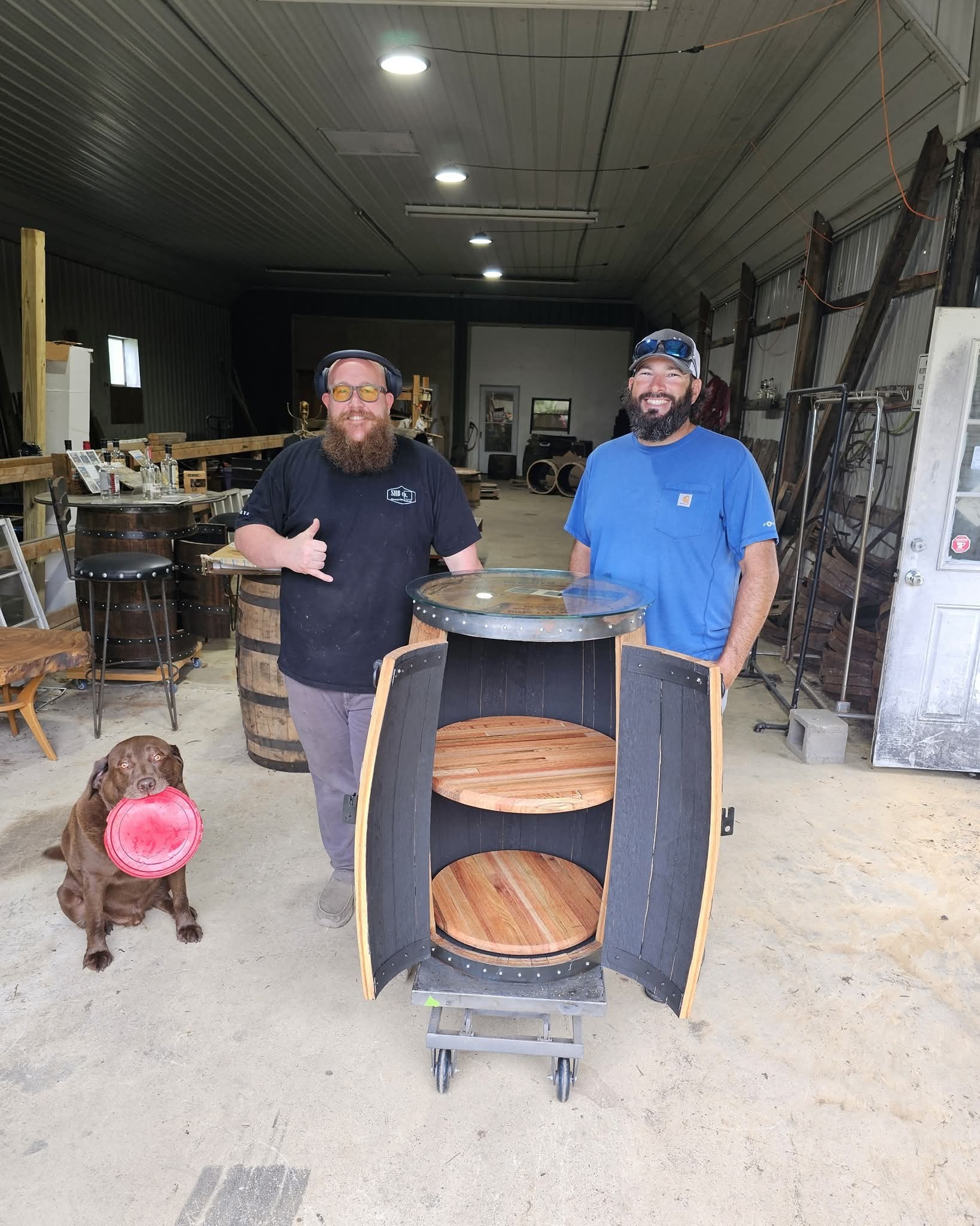 Nick and Ryan stand behind the open barrel cabinet at the workshop handoff.