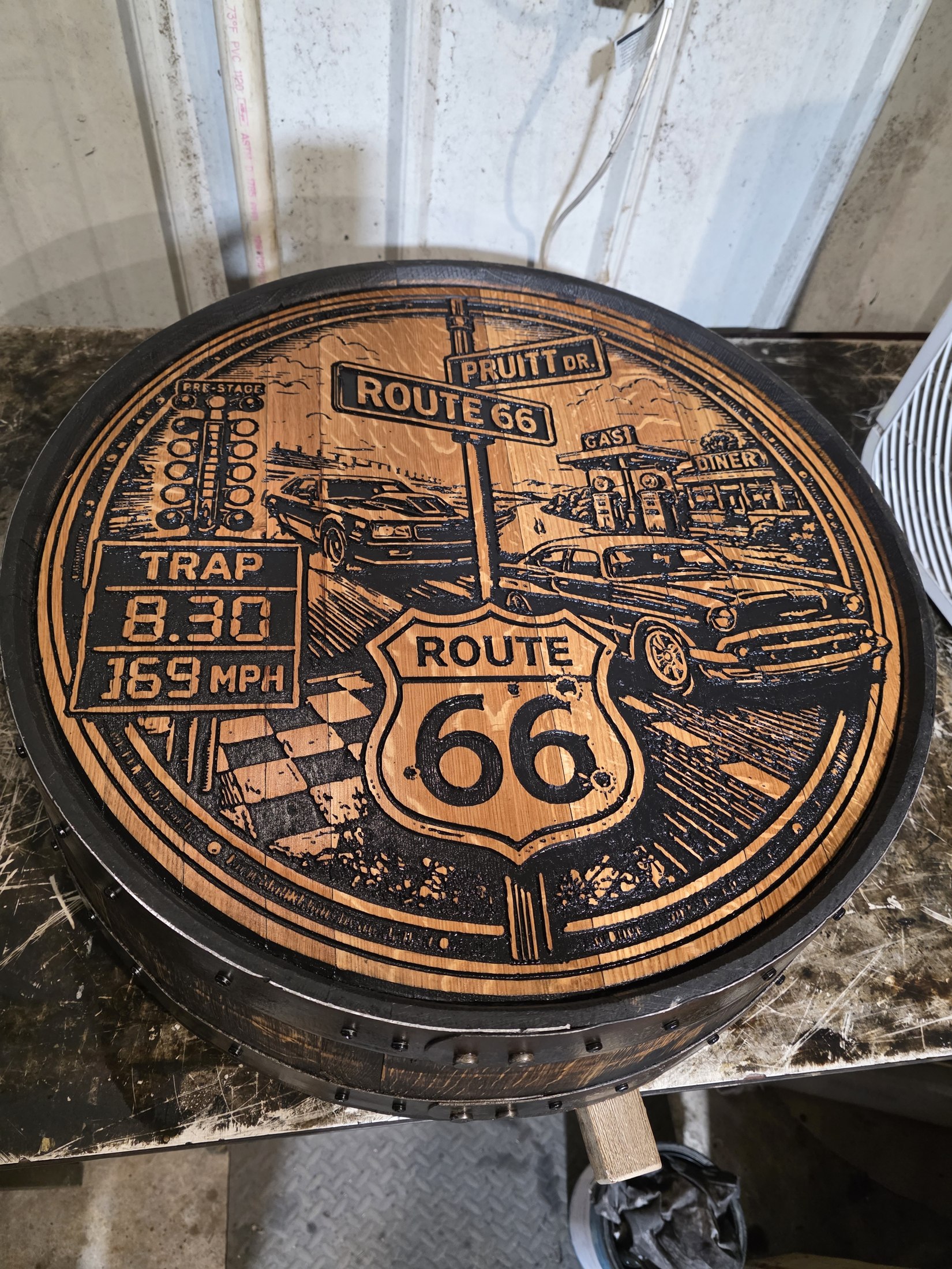 Pruitt’s engraved barrel cap combines his Monte Carlo, an 8.30 trap-time board, a Chevy Bel Air cruiser scene and Route 66 graphics.