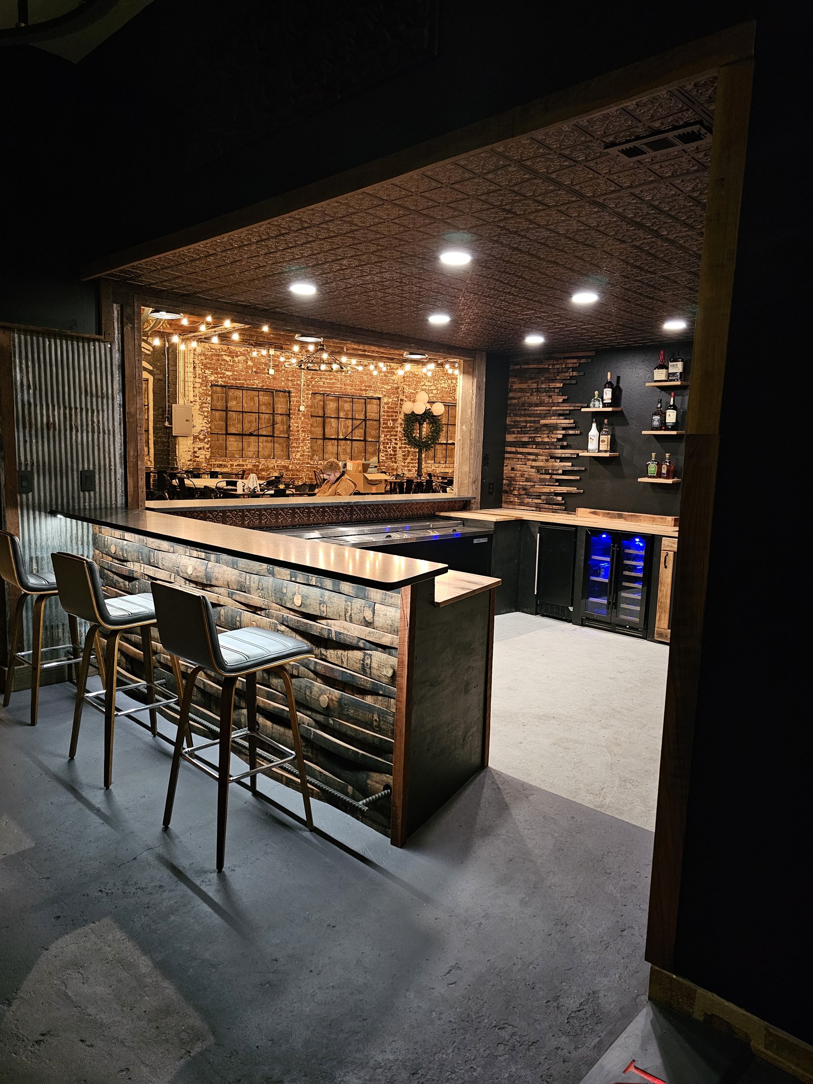 Angled view along the finished Rustic Roots bar with stave facing and back-bar shelving.
