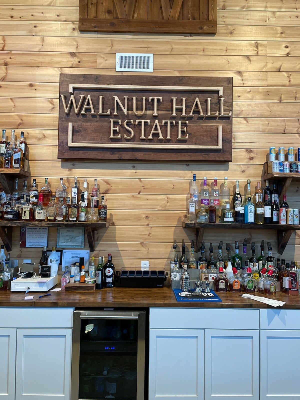 Walnut Hall Estate sign mounted above a bar.