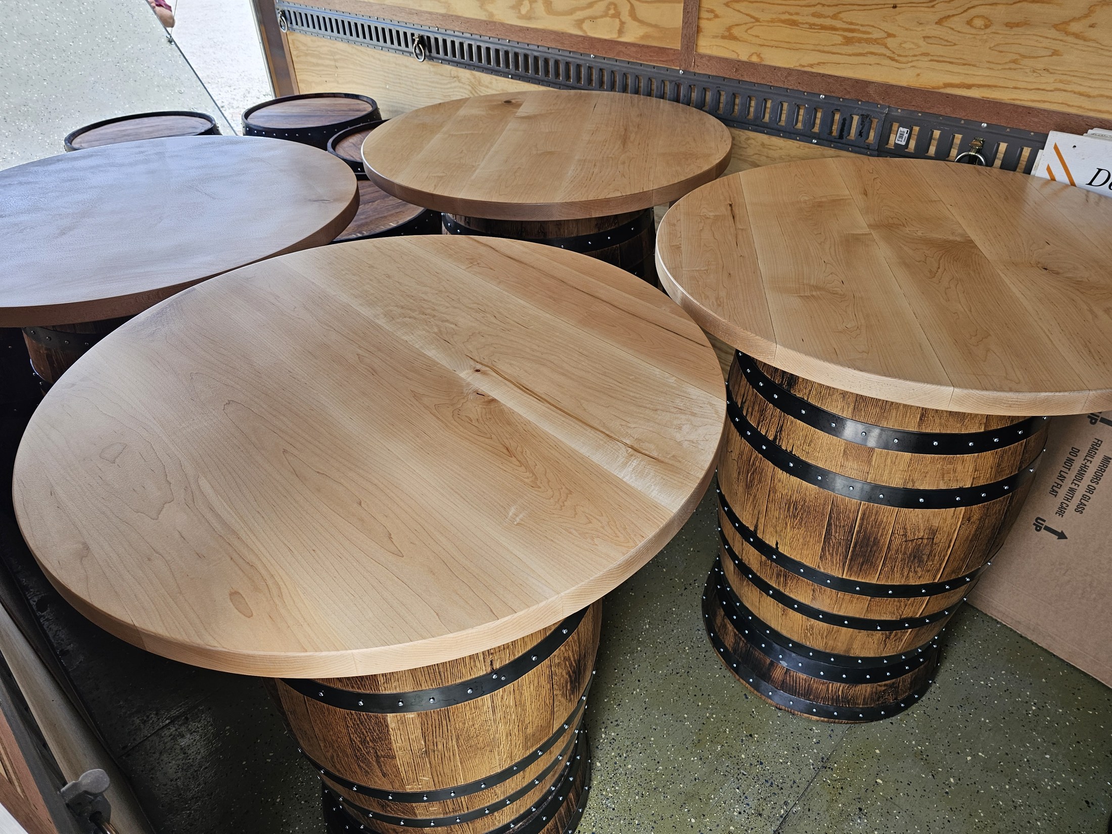 Four barrel cocktail tables with round figured-maple tops grouped in the SHB workshop.